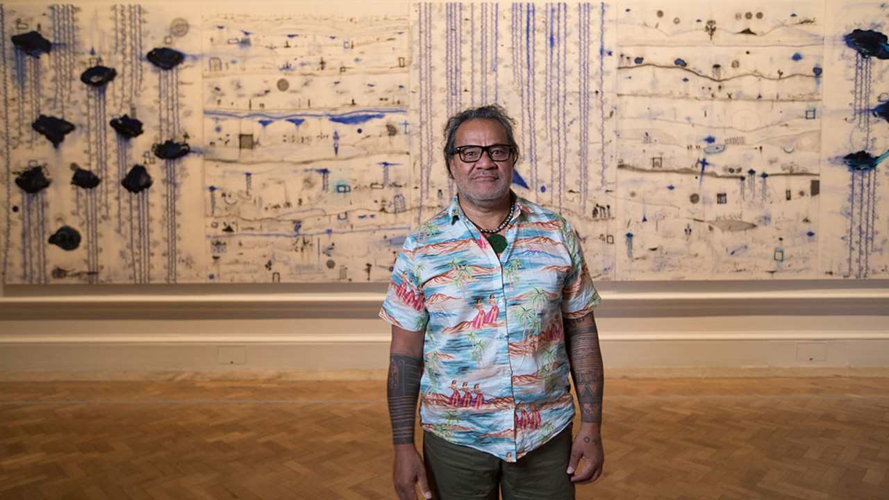 John Pule, in front of 'Kehe tau hauaga foou - To All New Arrivals', 2007, in the Memory and Commemoration room in the Oceania exhibition at the Royal Academy of Arts, London, 29 September – 10 December 2018  