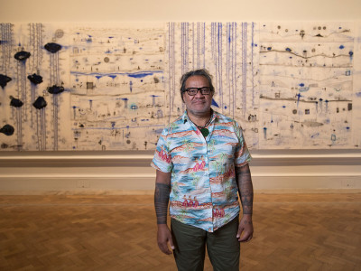 John Pule, in front of 'Kehe tau hauaga foou - To All New Arrivals', 2007, in the Memory and Commemoration room in the Oceania exhibition at the Royal Academy of Arts, London, 29 September – 10 December 2018  