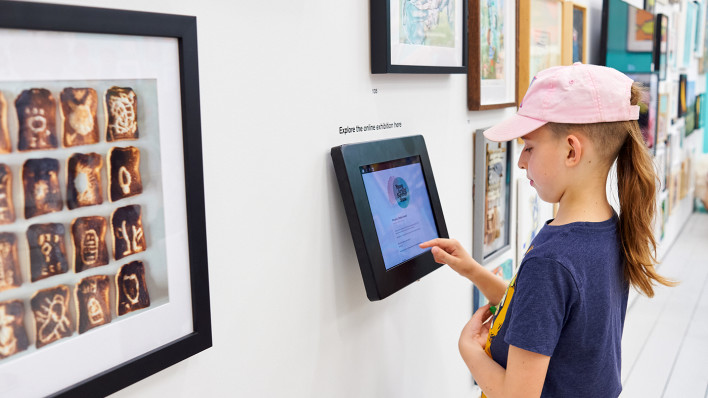 A visitor viewing the online exhibition on a touchscreen