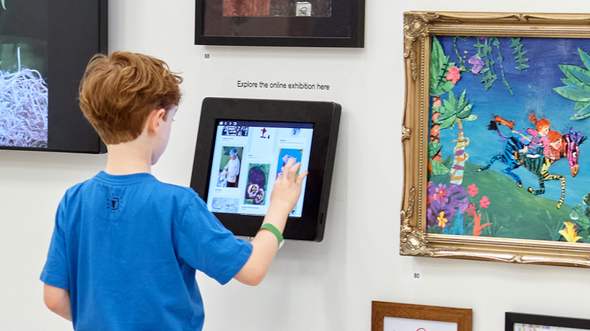 Looking at an iPad showing the online exhibition in the Young Artists' Summer Show