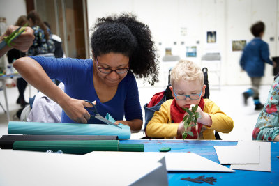 An RA volunteer works with a child to make a ‘forest in a box’ in response to the RA’s recent Kiefer show, at a family workshop for children with special educational needs