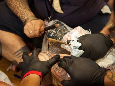 Te Rangitu Netana using the uhi (traditional Maori Ta Moko tools)