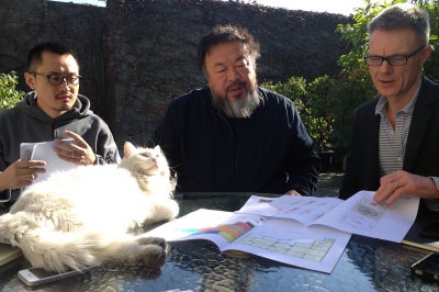 Ai Weiwei and Tim Marlow, the RA's Director of Artistic Programming, look at floor plans of the RA's Main Galleries while 'meeting cat' looks on