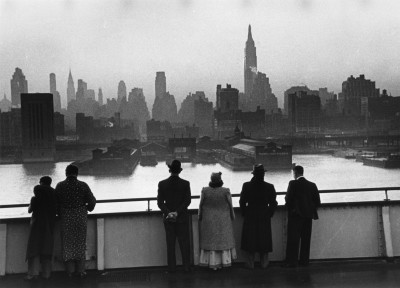 Passengers on board the Cunard White Star liner Queen Mary view the New York skyline as the ship docks in Manhattan at dawn, 1939.