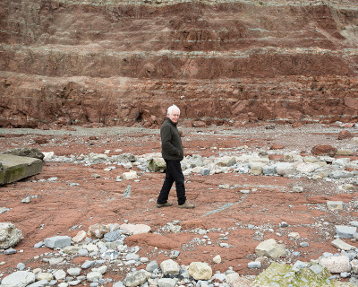 Terry Setch RA walks in front of the cliffs of Penarth Beach in South Wales, where he gathers the materials for his paintings