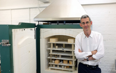 Portrait of Edmund de Waal standing by the kiln in his studio