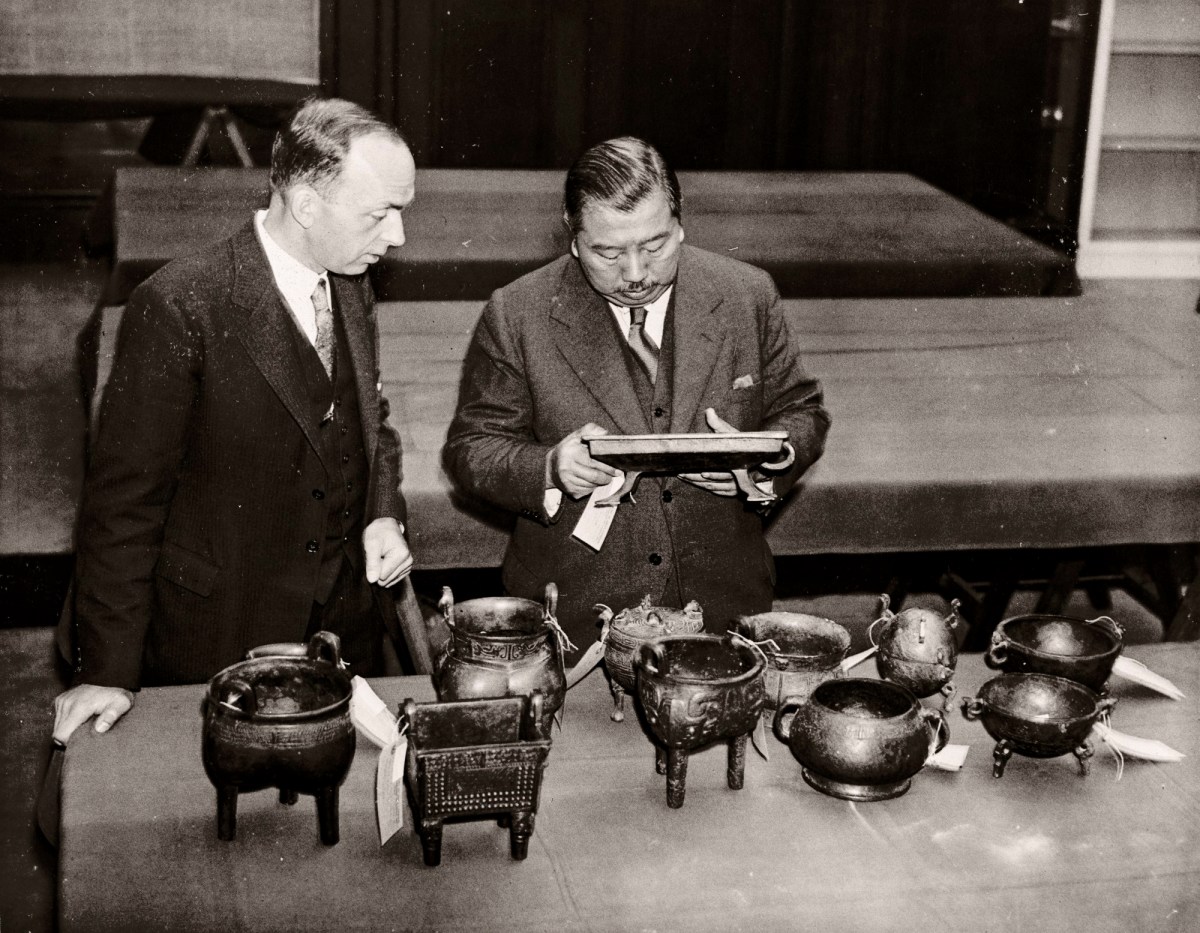 Topical Press Agency, Zheng Tianxin (Dr F. T. Cheng) and Mr F.St. G. Spendlove examining exhibits. The International Exhibition of Chinese Art at the Royal Academy 1935-6. Photograph by an unknown photographer from Topical Press Agency