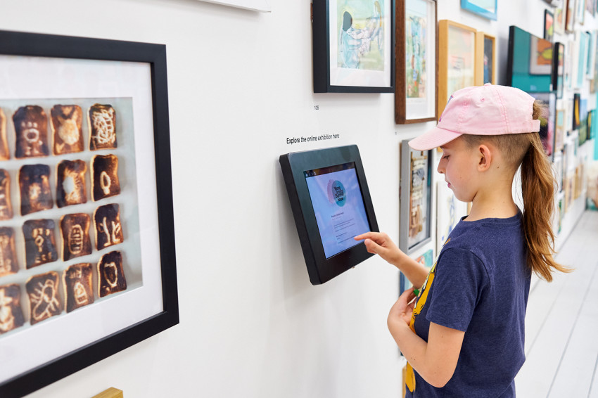 A visitor viewing the online exhibition on a touchscreen