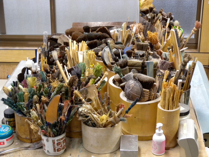 A variety of brushes are used to spread colour onto the woodblocks